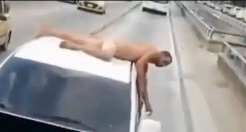 Wife humiliates cheating husband by making him lie naked on car in street