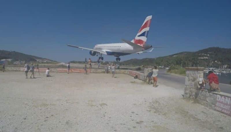 tourists attempts to take photos with landing aircraft in greece