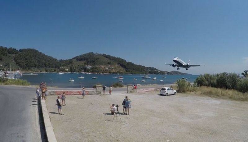 tourists attempts to take photos with landing aircraft in greece