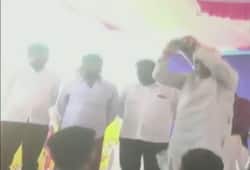 Karnataka Revenue Minister RV Deshpande throws sports kits from a stage to athletes Karwar