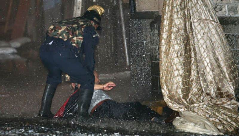 A security personnel is seen helping out a man who was rescued from the hotel during the terror attack.