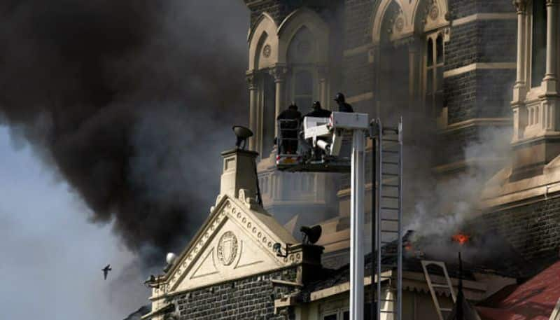 Fire brigade officers fighting to douse the fire near the main dome of Taj Mahal Hotel.