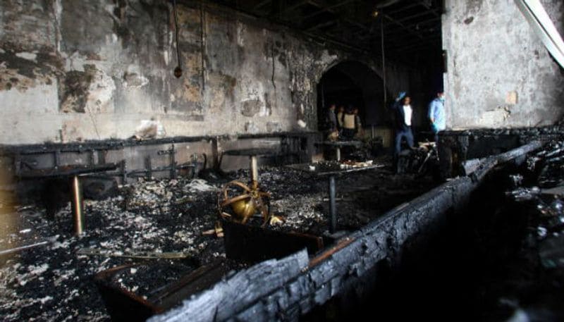 Security officials survey a destroyed room inside the Taj Mahal Palace and Tower Hotel after the armed siege.