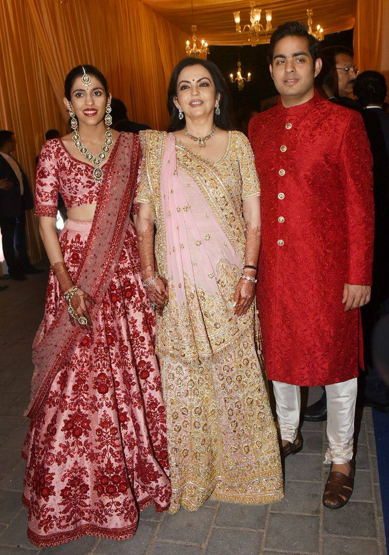 Shloka Mehta and fiance Akash Ambani twin outfits as they pose with mother of the bride, Neeta Ambani.