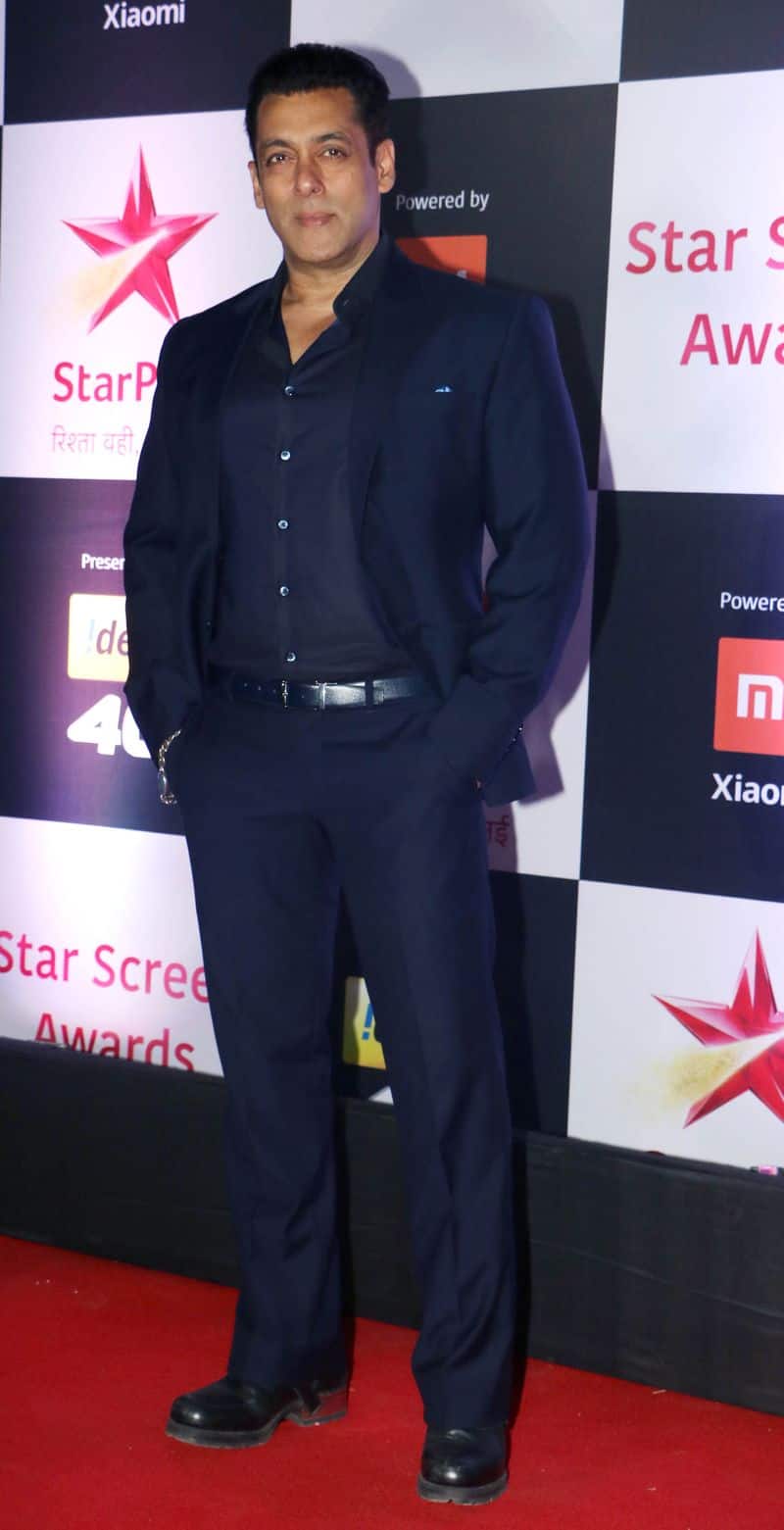 Salman Khan dressed in an all navy-blue outfit with his trademark chain bracelet.