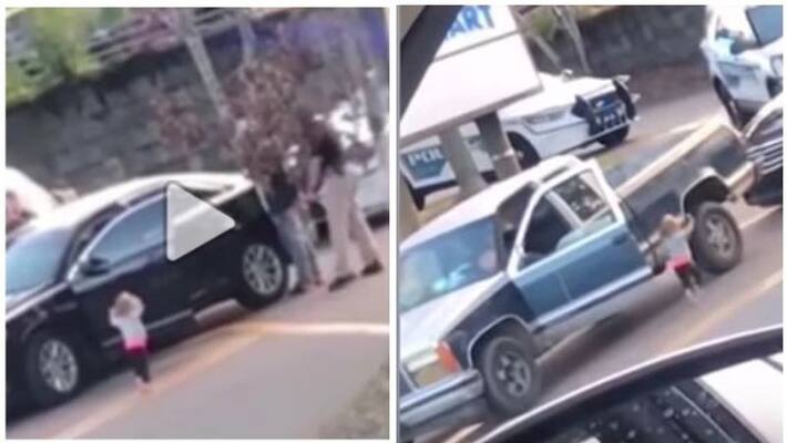 A toddler walks toward police with her hands up as her dad gets arrested A toddler walks toward police with her hands up as her dad gets arrested