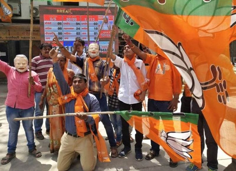 जश्न में BJP झंडा लहराते कार्यकर्ता