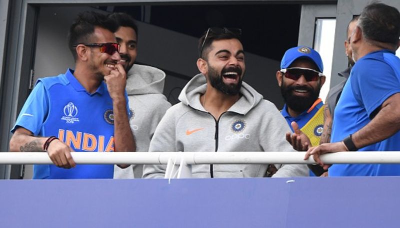 Kohli enjoys a joke with teammmates on the players balcony.