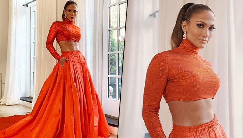Jennifer Lopez attended the CFDA Fashion Awards last night (June 4) and set the red carpet on fire. The singer, songwriter and actress showed off her perfect abs in an orange two-piece Ralph Lauren number.