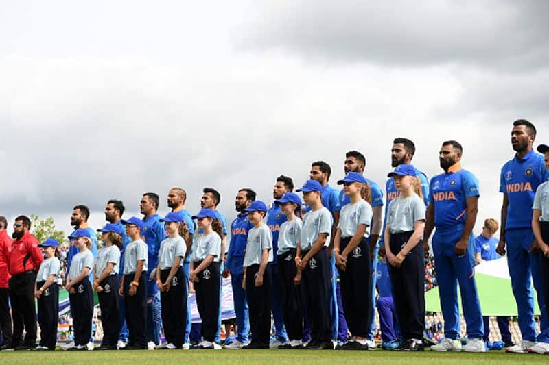 Indian players line up on the ground as the national anthem plays
