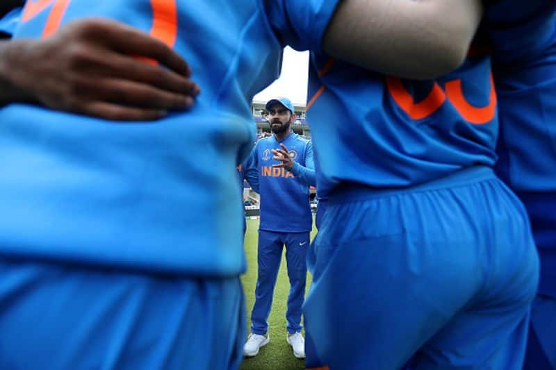 Kohli talks to his players in a huddle before entering the field to defend 353