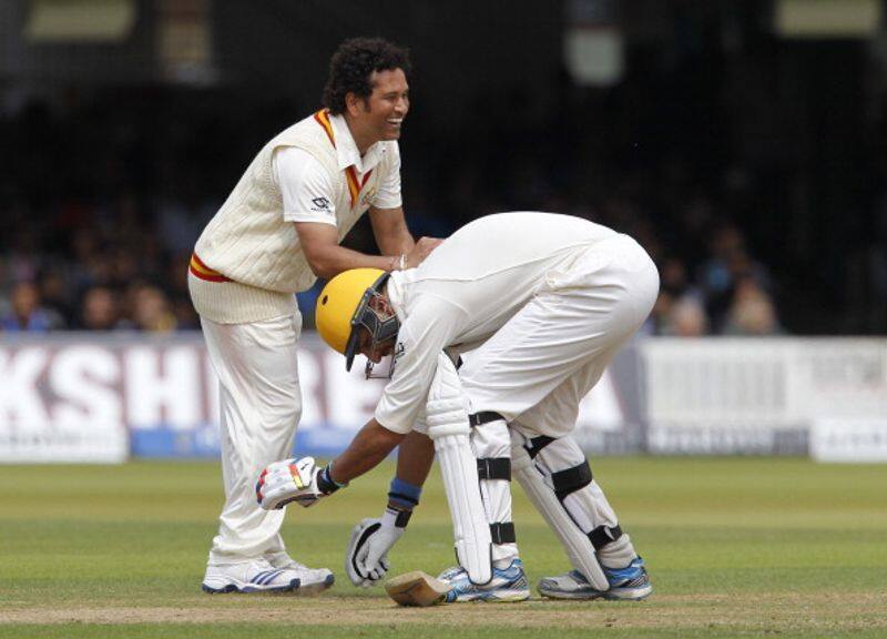 Yuvraj touches his idol Sachin Tendulkar's feet during an exhibition match