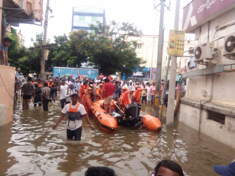 వర్షపు నీటిలో ఉన్న ప్రజలను సురక్షిత ప్రాంతాలకు తరలిస్తున్న ఎన్డీఆర్ఎఫ్ సిబ్బంది