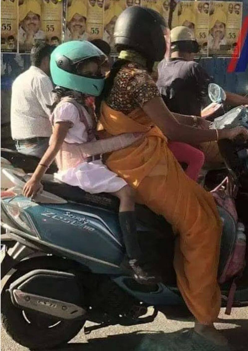 a mother made her baby to wear helmet and belt during the bike travel in tamilnadu