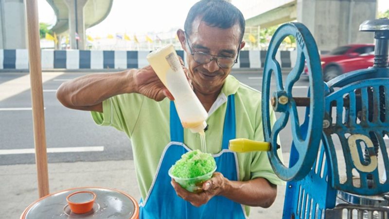 Old uncle sells icecream to support disabled son walking in heatwave at Bangkok