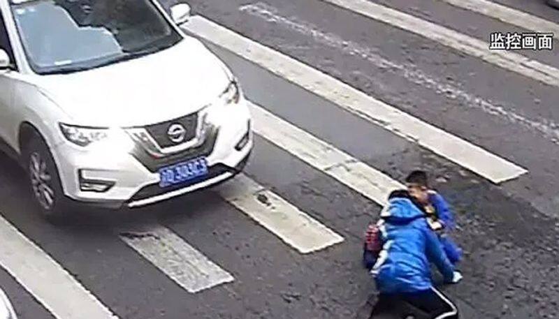little boy kicks car and tells off driver after he knocks down mother on zebra crossing