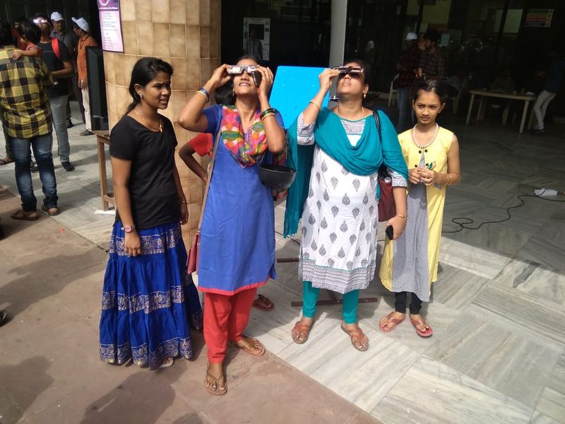 கிரகணத்தை பார்த்து மகிழும் பெண்கள்