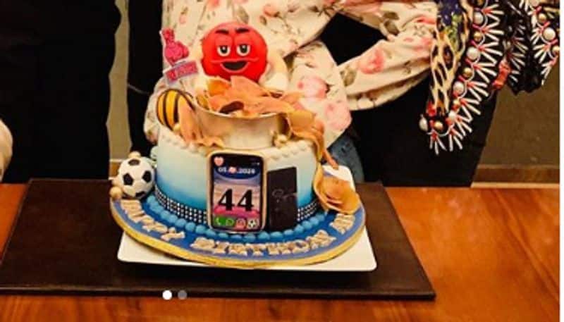 In the first picture, the Bachchan family is seen posing for the camera before cutting the cake. Abhishek's love for sports reflects on his birthday cake as well.