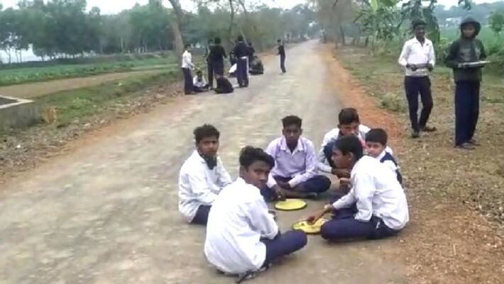 School boys eat mid day meal in main road School boys eat mid day meal in main road