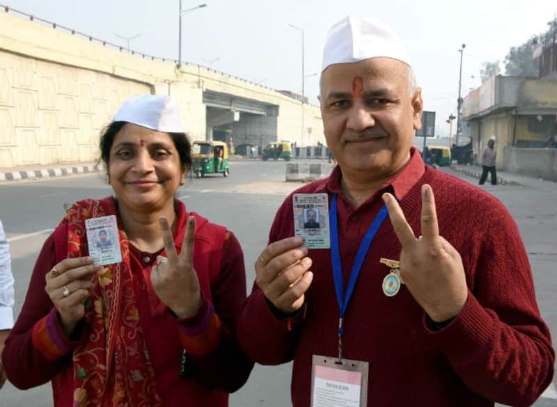 Delhi Deputy Chief Minister Manish Sisodia along with his wife show their finger marked with indelible ink after casting their vote during the Delhi Assembly elections, at Pandav Nagar in New Delhi on Saturday.