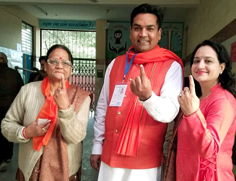 BJP leader Kapil Mishra and his family display their ink marked finger after casting votes at a polling booth during the Delhi Legislative Assembly elections, in New Delhi on Saturday.