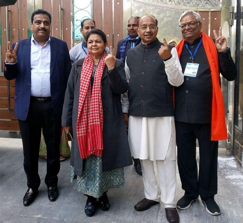 Senior BJP leader Vijay Goel and his wife Preeti Goel show their fingers marked with indelible ink after casting their vote during the Delhi Assembly election, in New Delhi on Saturday.