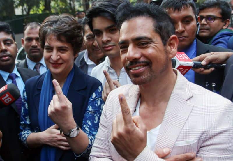 Congress Party General Secretary Priyanka Gandhi Vadra along with husband Robert Vadra show finger marked with indelible ink after casting their vote during the Delhi assembly elections, in New Delhi on Saturday.