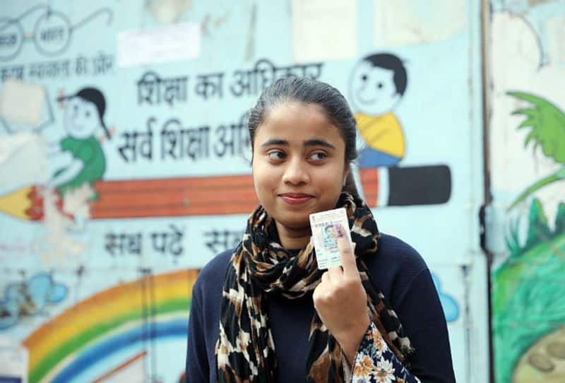 A first time voter shows her finger marked with indelible ink after casting her vote during the Delhi Assembly elections, in New Delhi on Saturday.