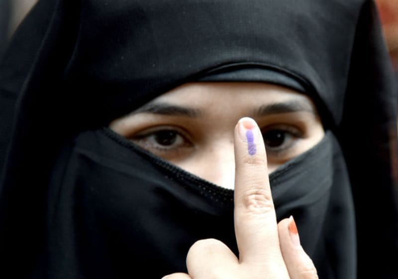 A female voter shows her ink-marked finger after casting her vote in the Delhi Legislative Assembly elections near Turkman Gate of Old Delhi in New Delhi on Saturday.