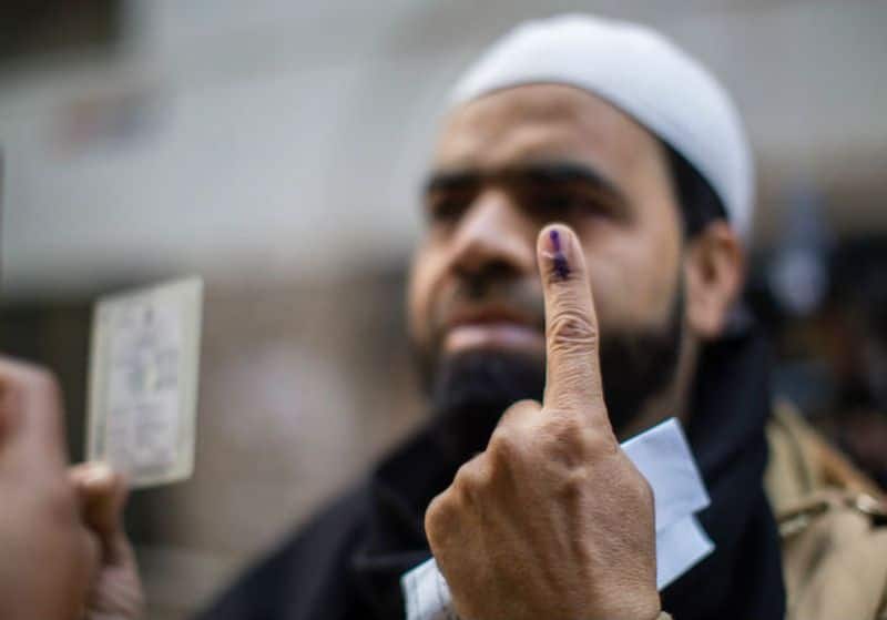 An Indian Muslim shows his indelible ink marked finger outside a polling station in Shaheen Bagh after casting his vote on February 8, 2020 in Delhi.