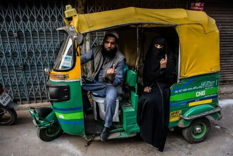 An Indian Muslim couple show their Indelible ink marked fingers outside a polling station, after casting their votes on February 8, 2020 in Shaheen Bagh area of Delhi.