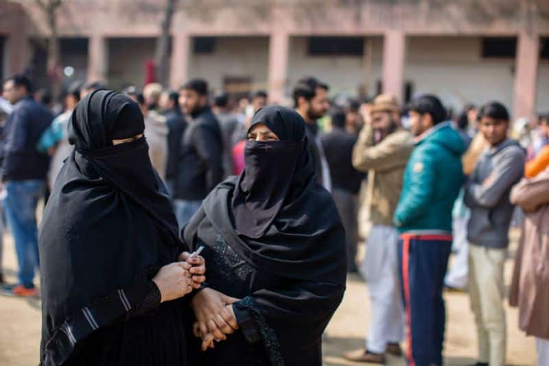 Indian Muslim women wait to cast their votes outside a polling station on February 8, 2020 in Shaheen Bagh area of Delhi.