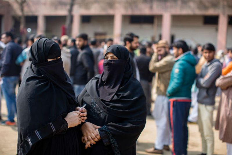 Indian Muslim women wait to cast their votes outside a polling station on February 8, 2020 in Shaheen Bagh area of Delhi.