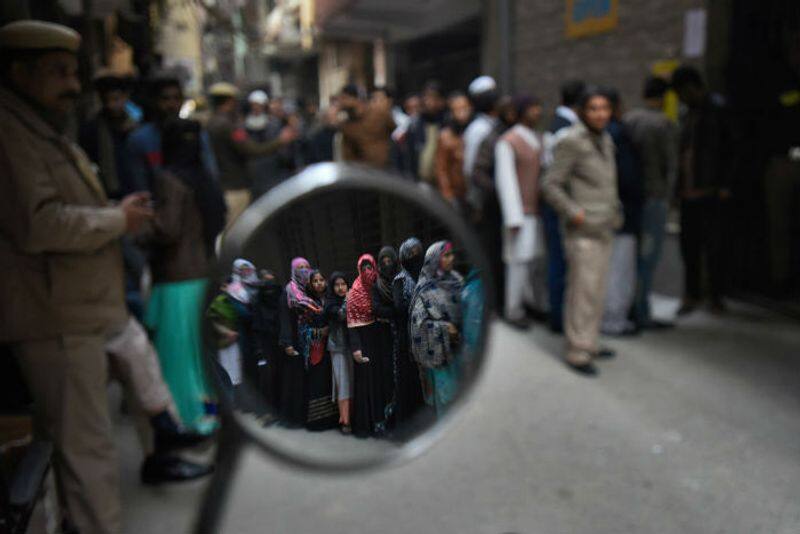 Voters stand in a queue to cast their vote for Delhi assembly election, at Shaheen Bagh, on February 8, 2020 in New Delhi.