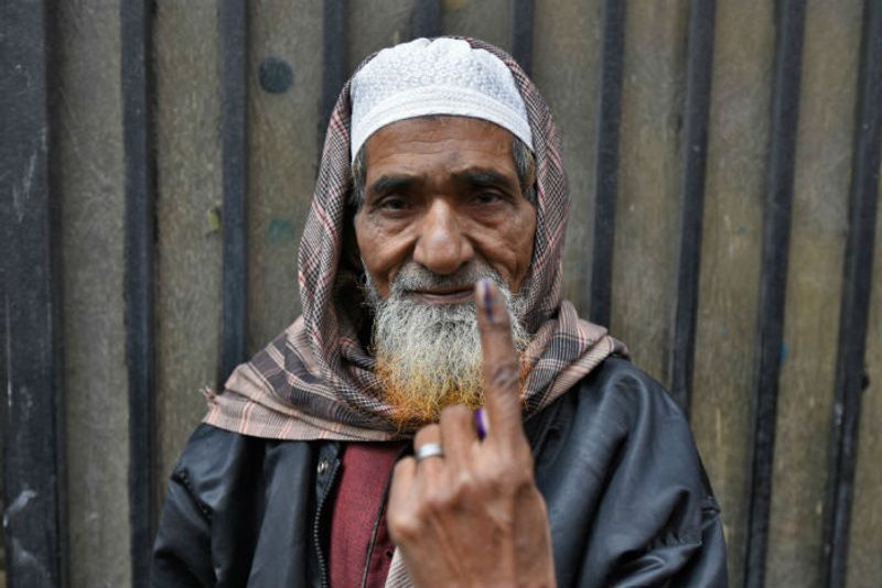 An elderly voter shows his ink marked finger after casting his vote for Delhi assembly election, at Shaheen Bagh, on February 8, 2020 in New Delhi.