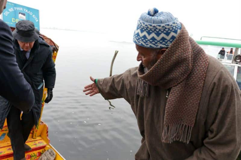 A local Kashmiri welcomes EU convoy at the bank of Dal Lake. (Photograph: Adil AbassBarcroft Media via Getty Images)