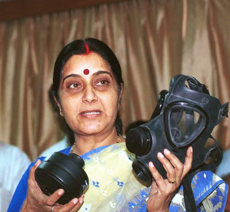 India's health minister Sushma Swaraj demonstrates the use of a nuclear-biological and chemical warfare mask to tackle the SARS virus on April 24, 2003. (Photo by Pallava BaglaCorbis via Getty Images)