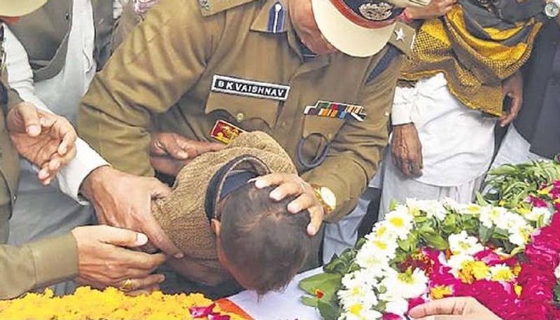 धौलपुर जिले के जैतपुर के रहने वाले भागीरथ कंसाना के पार्थिव शरीर पर माथ टेककर नमन करता उनका मासूम बेटा। अपने पति की शहादत पर गर्व करते हुए पत्नी ने कहा था, मेरे बच्चे दुश्मन से बदला लेंगे। वो अपने बच्चों को भी सेना में भेजेगी।