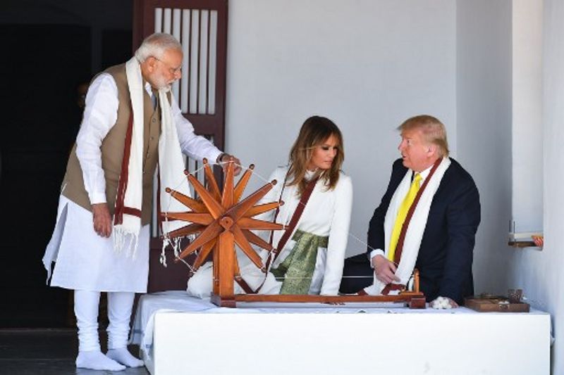 First Lady Melania descended from Air Force One wearing a full-sleeved wide-legged white jumpsuit paired with a deep green coloured knotted belt, accentuating her waist. Melania kept her hair loose with a neat middle partition and slight waves at the ends.