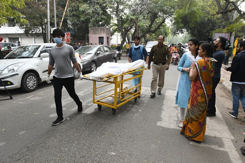जीटीबी अस्पताल के बाहर, हिंसा में मारे गए व्यक्ति का शव ले जाते हुए।