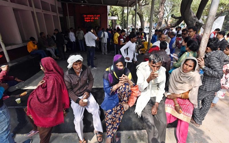 जीटीबी अस्पताल की तस्वीर, पोस्टमॉर्टम के बाहर लोग अपनों की पहचान के लिए इंतजार में बैठे हैं।