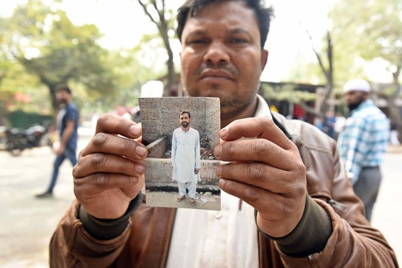 अहमद अली अपने भाई फिरोज अहमद (35) की तस्वीर दिखाते हुए। अहमद अली के भाई चार दिन से गायब हैं। यह कारावल नगर के रहने वाले हैं। हिंसा के बाद भाई का कुछ पता नहीं चला तो उसकी तस्वीर लेकर जीटीबी अस्पताल पहुंच गए।