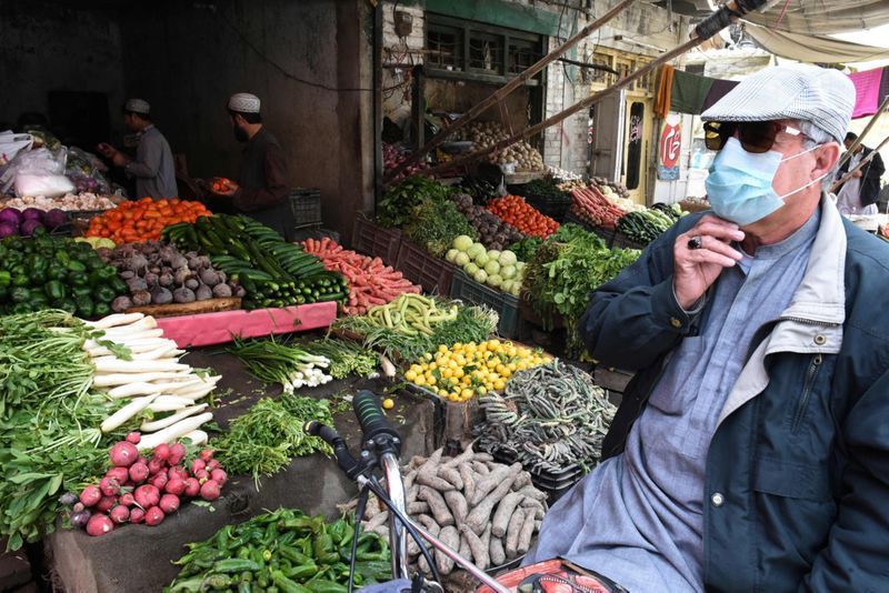 पाकिस्तान के क्वेटा में सब्जी खरीदता एक शख्स। यहां अब जाकर लोग मास्क पहने नजर आ रहे हैं।