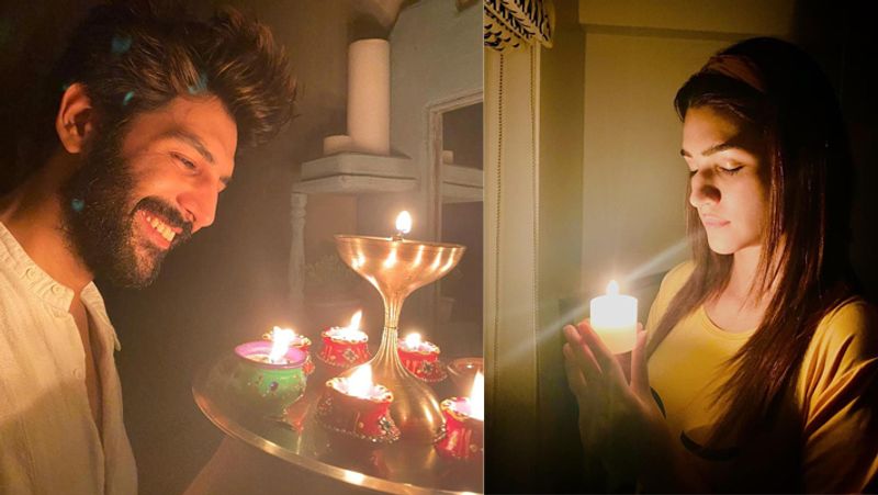 अपने-अपने घर में दीया जलाते कार्तिक आर्यन और कृति सेनन।