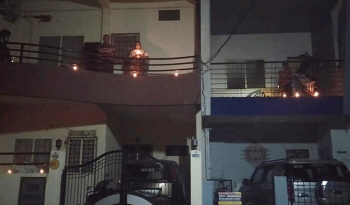 तस्वीर में दिखाई रहे है यह लोग इंदौर के हैं। वह कोरोना से निपटने के लिए रात नौ बजे अपने घरों की लाइटें बंद करके बालकनी में दिए जला रहे हैं।