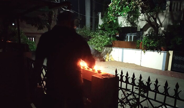 यह तस्वीर भी इंदौर शहर की है। जहां एक युवक अपने घर के मुख्य दरवाजे पर कोरोना को भगाने के लिए दिए जला रहा है।