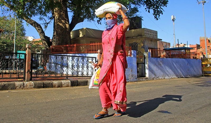 पैदल ही अपने घर की ओर जाती एक महिला।