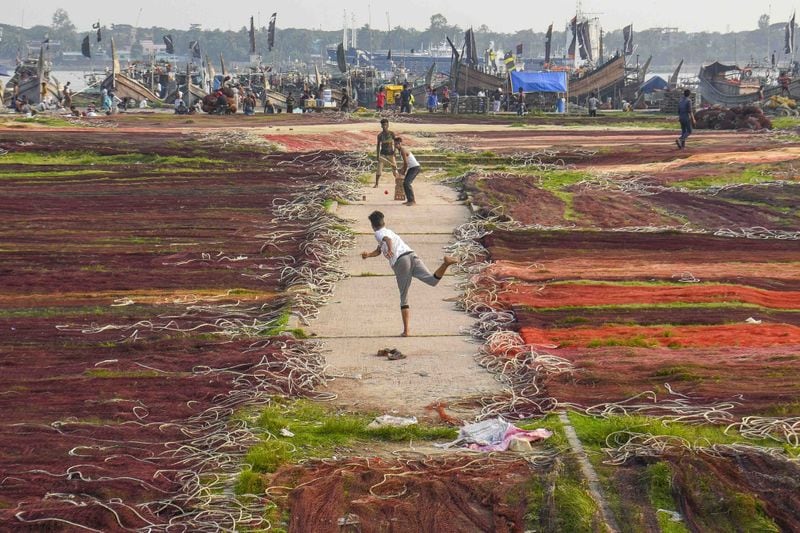 Shortlisted: Rajib Raihan (Daily Star, Bangladesh) Three youths play a game of cricket in one of the few spots in a field not covered by drying fishing nets at Fishery Ghat. December 23, 2019, Chattogram, Bangladesh. Photo courtesy: MCC.