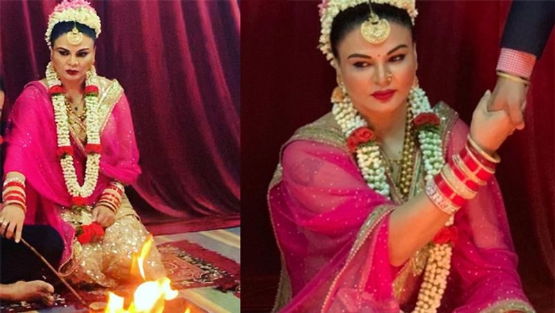 शादी की फोटोज में राखी पिंक-गोल्डन लहंगा, बालों में गजरा, मांग टीका और हाथों में भरी-भरी चूड़ियां पहने मुस्कराते नजर आ रही है। फोटोज में वे पति का हाथ थामे अग्नि के पास बैठी है हालांकि, उनके पति का चेहरा किसी भी फोटो में नजर नहीं आ रहा है।