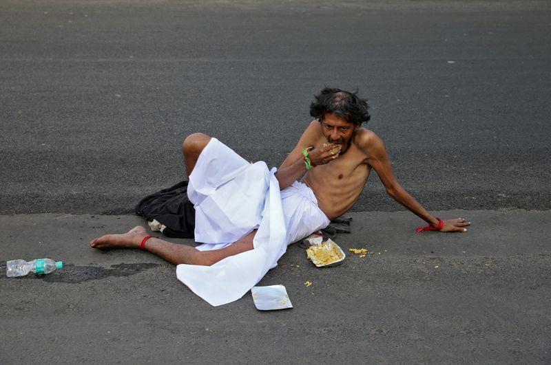 कोलकाता में सड़क पर खाना रखकर खाता शख्स। 